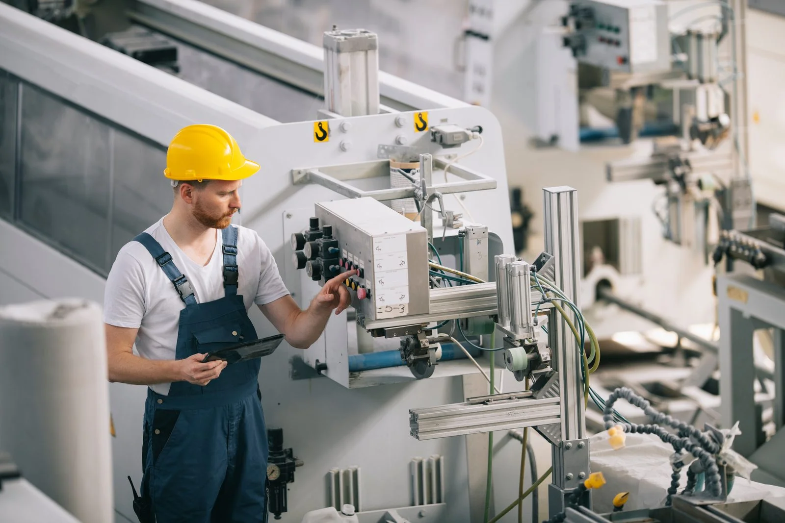 Ein Techniker stellt eine Maschine an der Produktionslinie ein