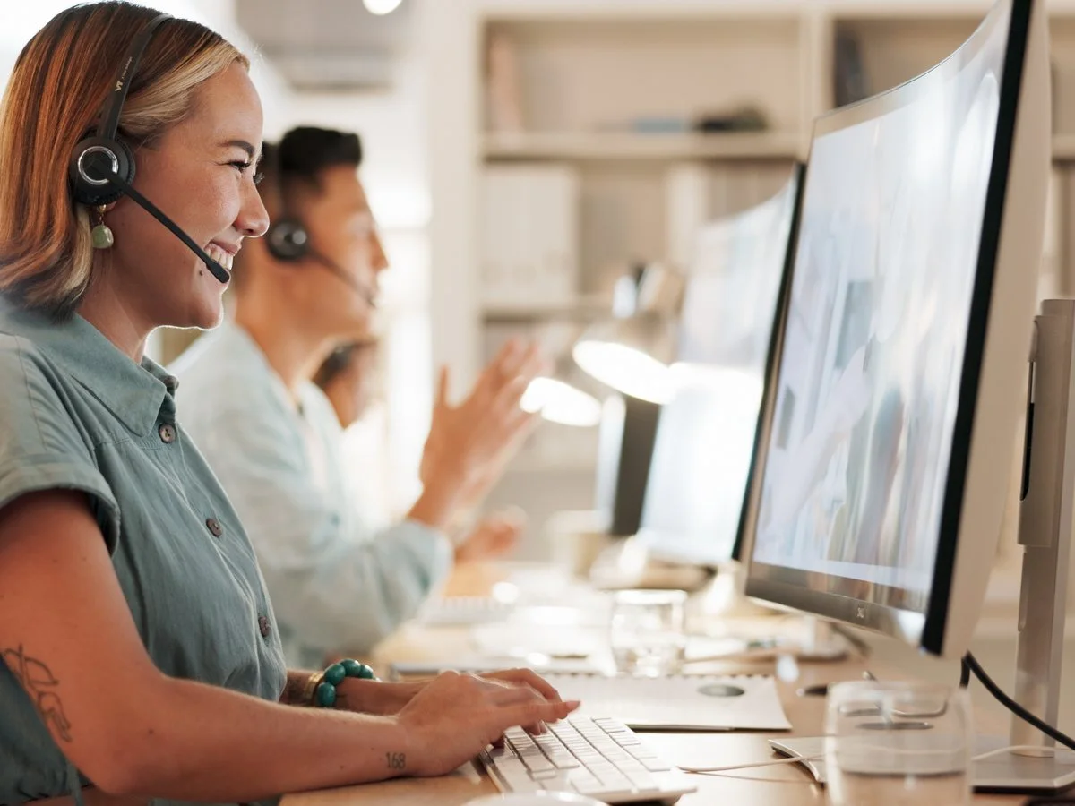 Eine Beraterin mit Headset an ihrem Platz im Support-Center
