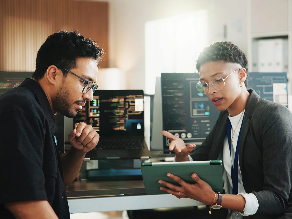 Two consultants talking over a tablet
