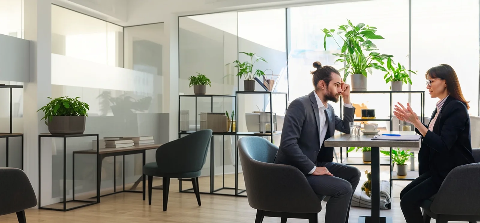 Deux personnes en rendez-vous autour d’une table de bureau