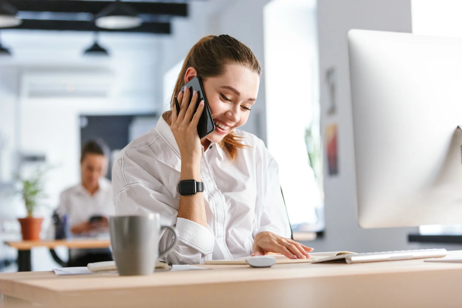 Une collaboratrice du service presse au téléphone, à son bureau
