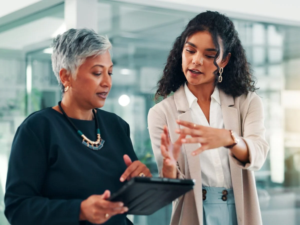 Dos mujeres conversan en torno a una tableta