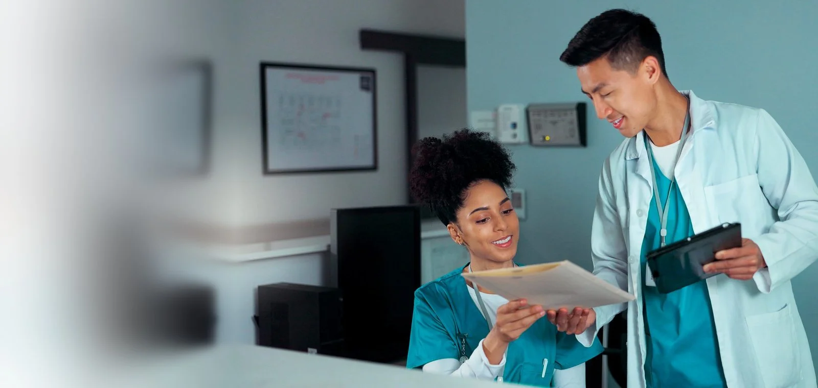 Two healthcare professionals looking at an assignment file
